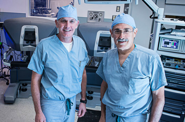 El Dr. O&#39;Malley y el Dr. Weinstein parados cerca de una máquina de otorrinolaringología